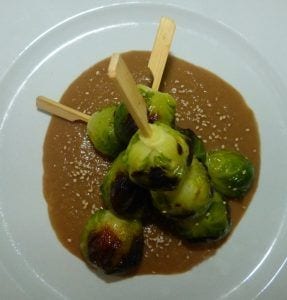 Brochetas de coles de Bruselas con salsa de cebolla caramelizada